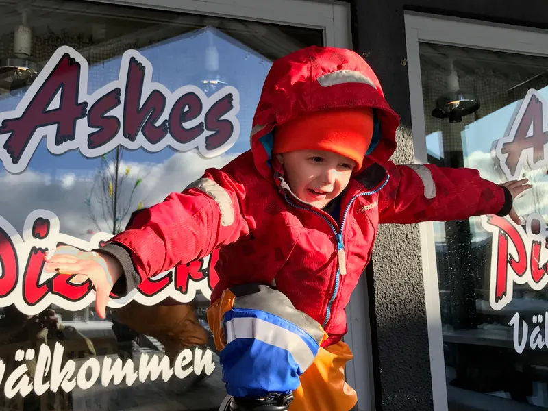 Viktor in a red winter jacket outside a diner